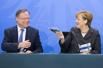 Bundeskanzlerin Angela Merkel überreicht das erste Münzset an den niedersächsischen Ministerpräsidenten Stephan Weil.