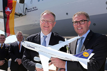 MP Weil und Lufthansa-Chef Carsten Spohr mit einem Modell des Flugzeugs; im Hintergrund das Original