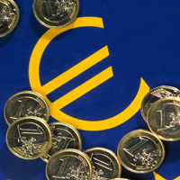 Euro-Münzen liegen auf einem Euro-Symbol