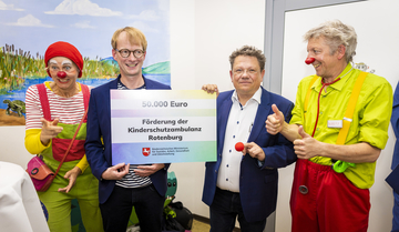 Gesundheitsminister Dr. Andreas Philippi überreicht einen symbolischen Check für die Kinderambulanz Rotenburg
