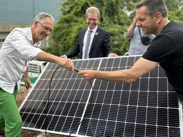 Wirtschaftsminister Olaf Lies schließt Solarpanele auf einem Dach an