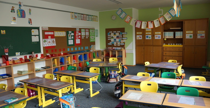 Blick in einen Klassenraum mit Schülertischen und Stühlen