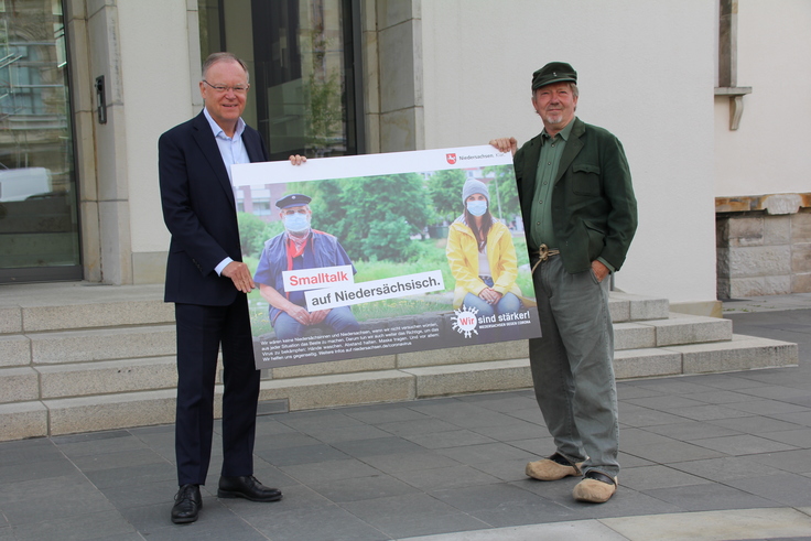 Ministerpräsident Stephan Weil mit Günther, der Treckerfahr mit einem Plakat zur Kampagne "Wir sind stärker! Niedersachsen gegen Corona"