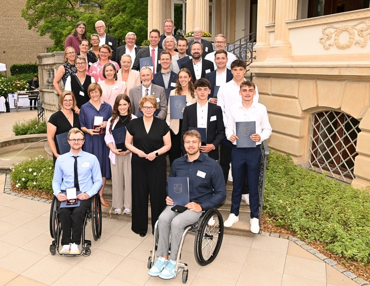 Die Preisträgerinnen und Preisträger der Niedersächsischen Sportmedaille 2024 posieren auf der Treppe des Gästehauses der Niedersächsischen Landesregierung.