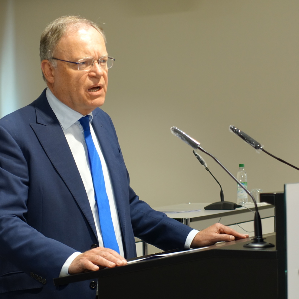 Ministerpräsident Stephan Weil steht an einem Podium und spricht.