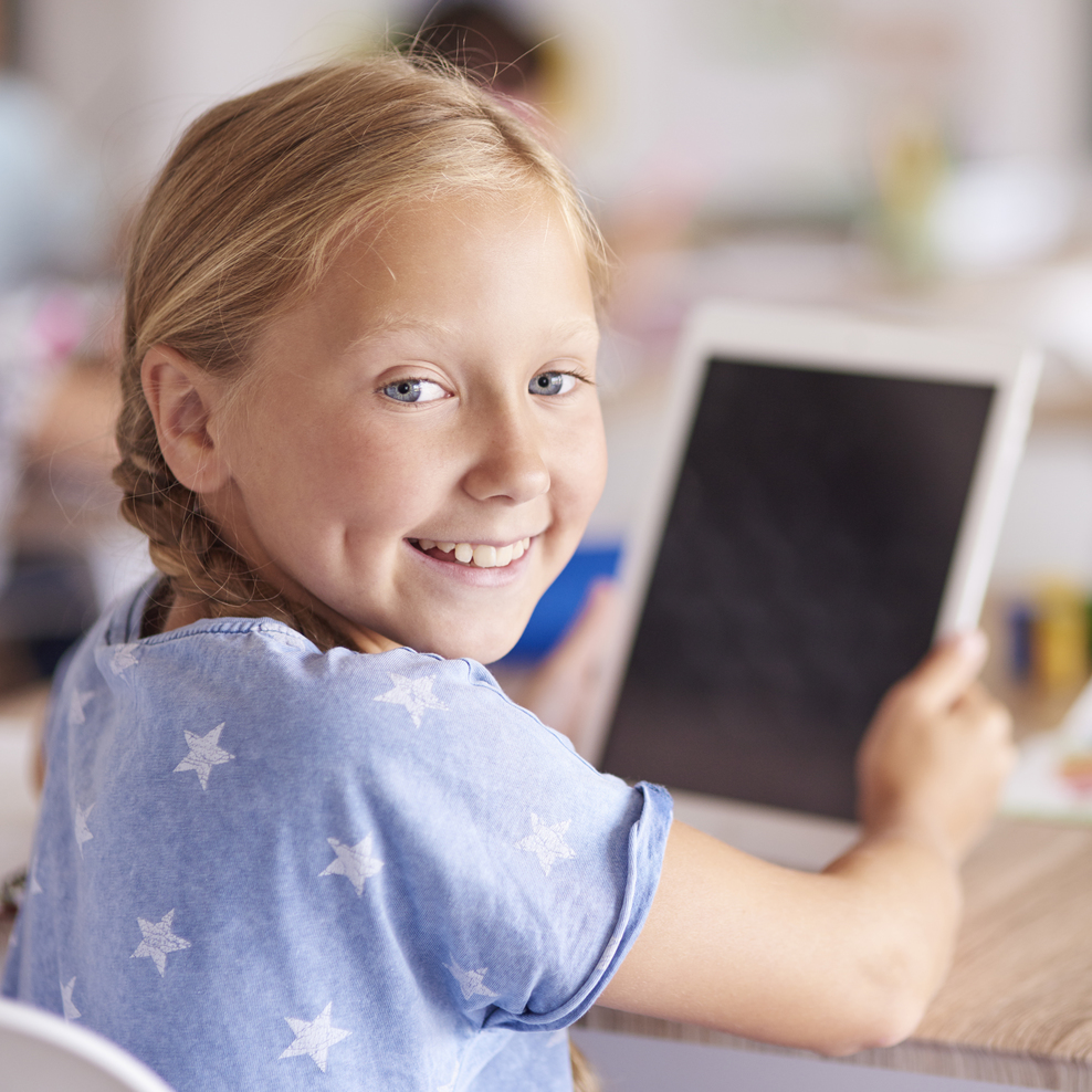 Symbolbild: Kind mit Tablet am Schreibtisch