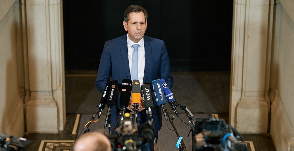 Ministerpräsident Olaf Lies vor vielen Mikrofonen und Kameraleuten.