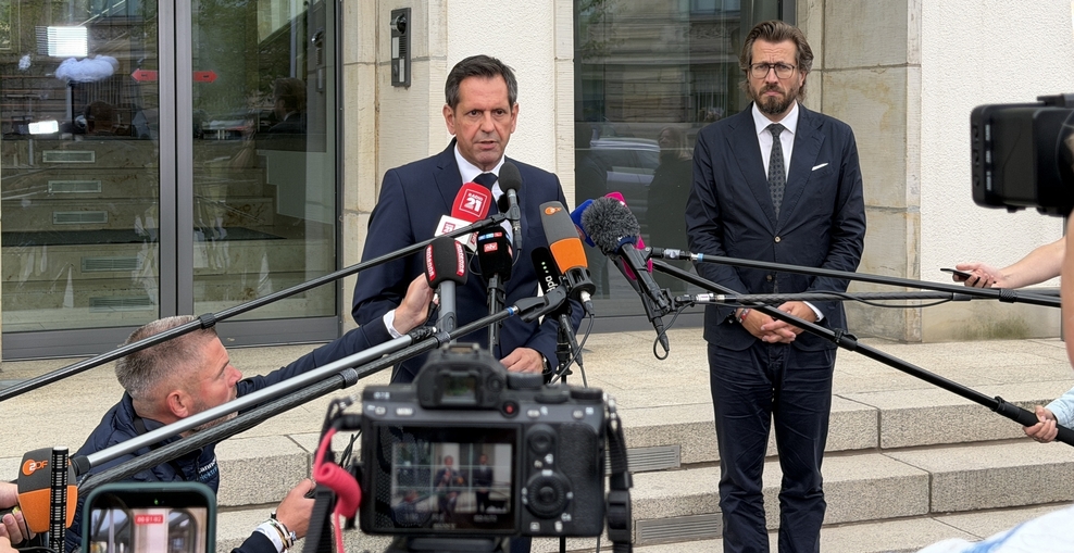 Ministerpräsident Olaf Lies steht vor der Niedersächsischen Staatskanzlei und spricht in vor ihm aufgebaute Mikrofone.