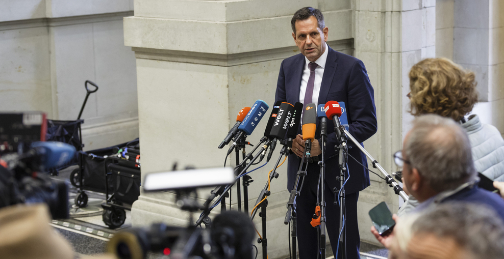 Ministerpräsident Olaf Lies steht vor Mikrofonen und spricht zur Presse.